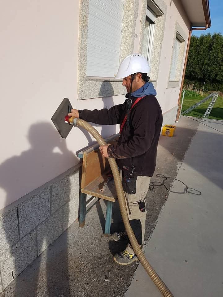 Operario aplicando aislamiento insuflado en la pared de una vivienda en A Coruña